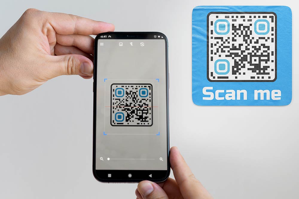 Mână care ține smartphone-ul stabil în timp ce scanează codul QR