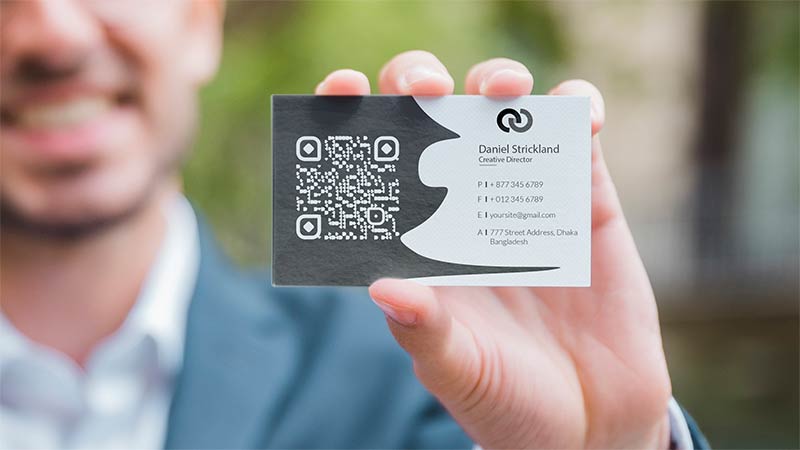 A man in a suit shows his business card
