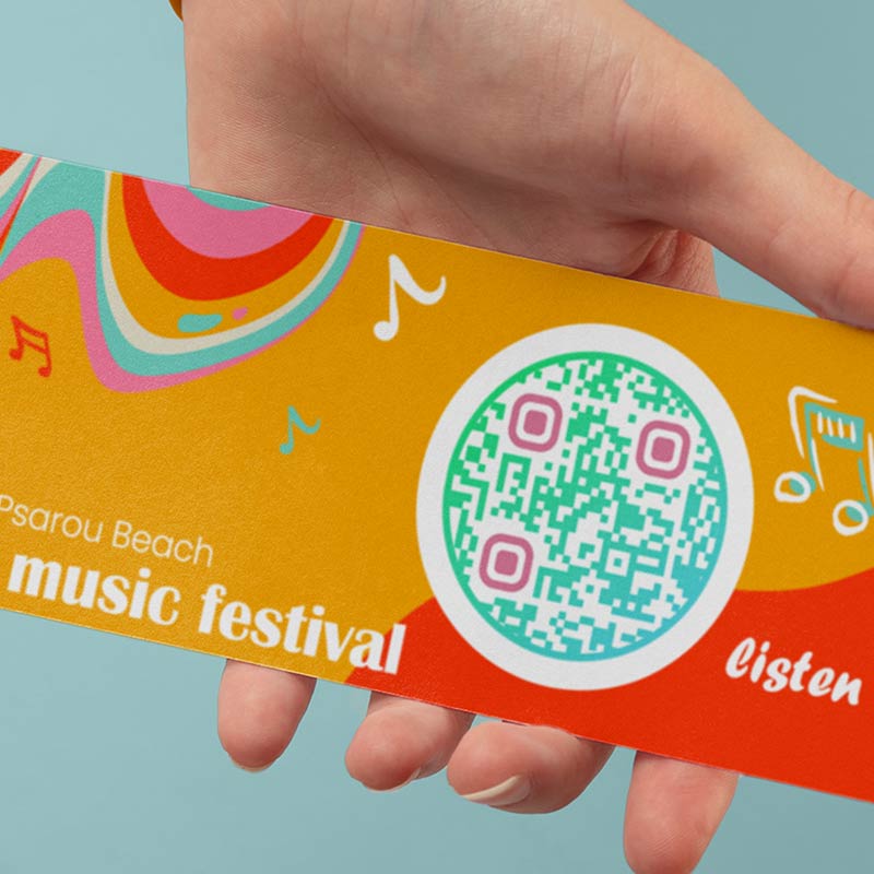 A hand holding a music festival flyer with audio QR code that leads to a demo